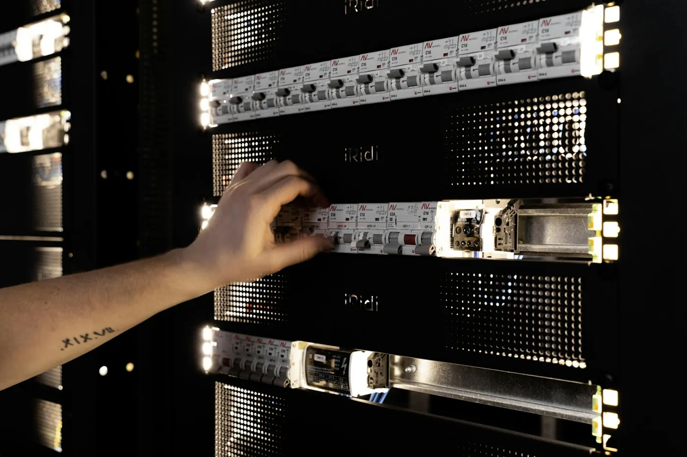 Engineer adjusting equipment in a glowing server rack