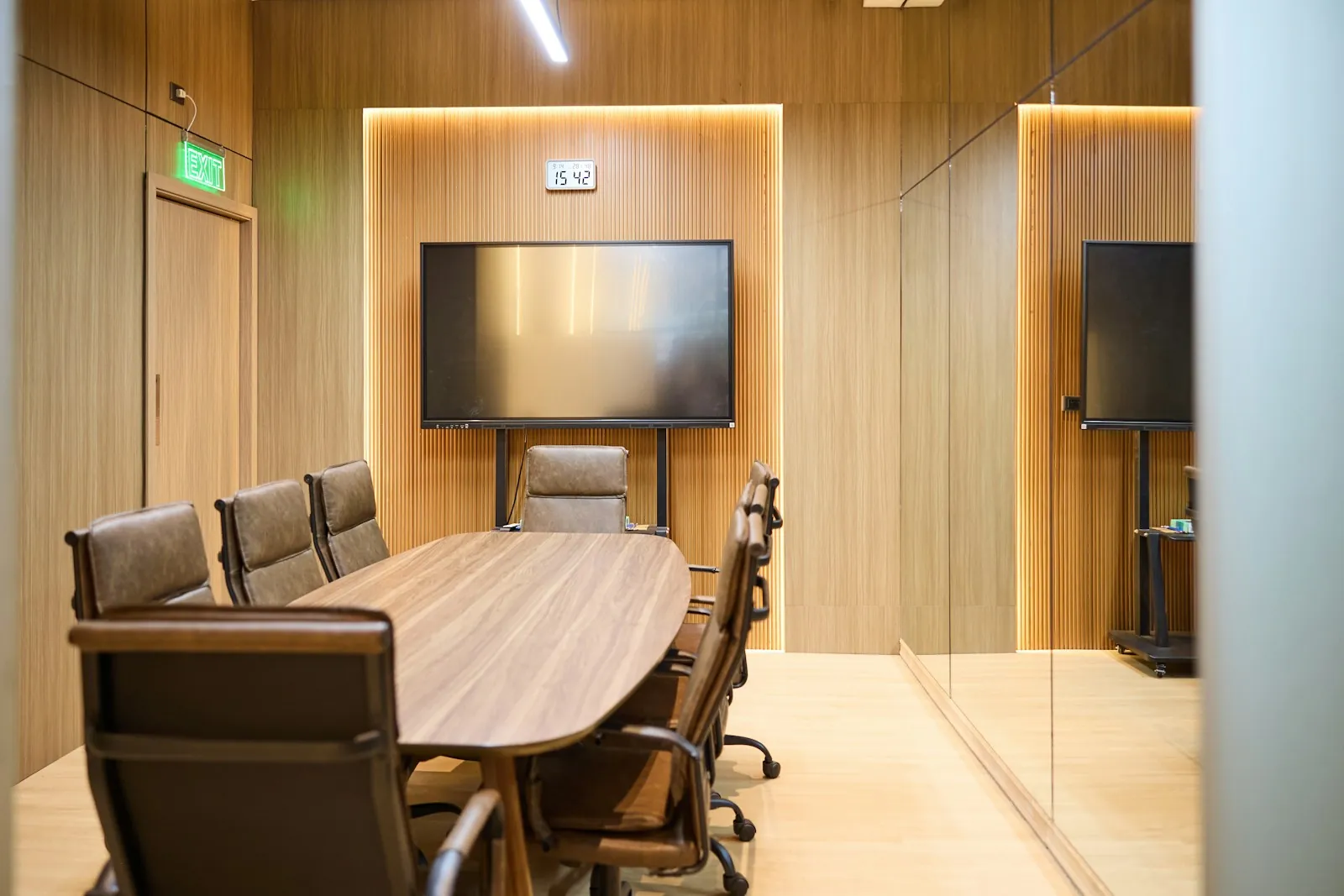 Modern meeting room with a display screen and wood panelling